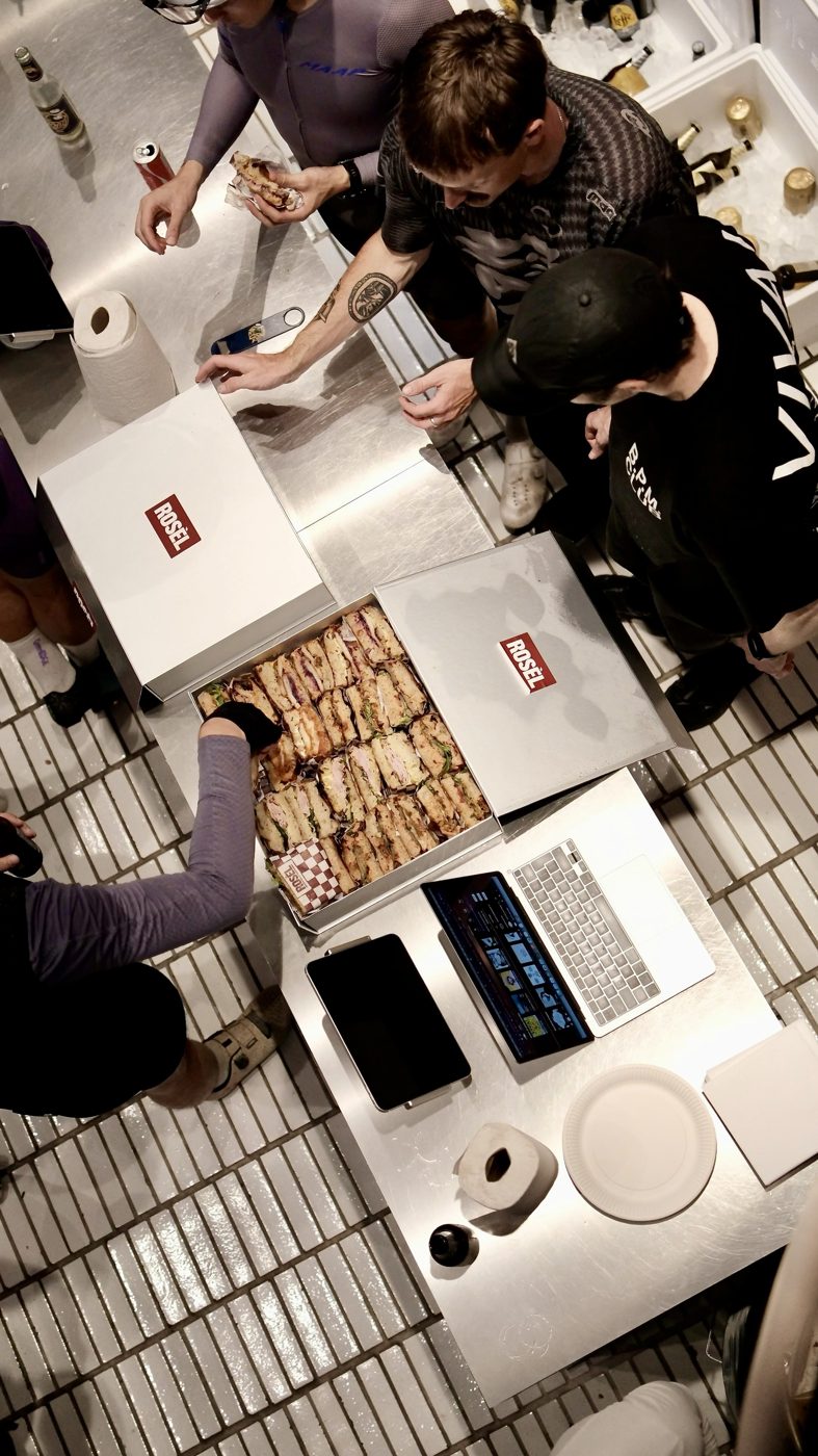 A team gathering around two open Rosèl catering boxes